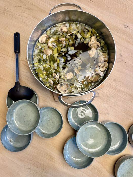 Marmite de bouillon aux poireaux et champignons, bols en céramique