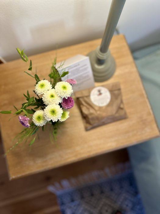 Bouquet de fleurs et petite attention sur la table de chevet