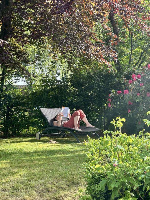 Lecture sur une chaise longue dans le jardin fleuri