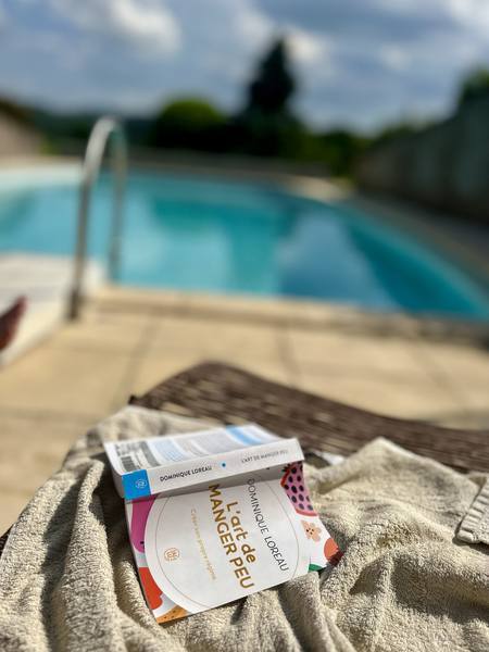 Livre posé sur une serviette au bord de la piscine