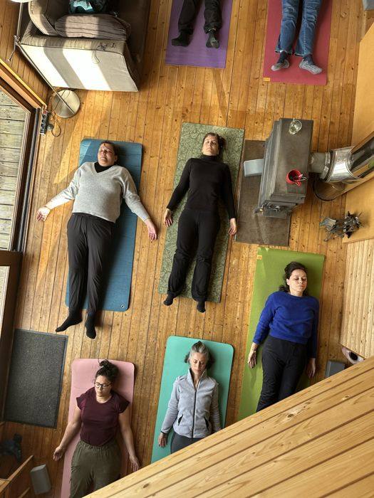 Groupe allongé sur les tapis de yoga, en relaxation
