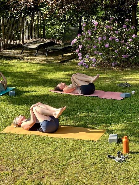 Séance de yoga sur tapis dans le jardin