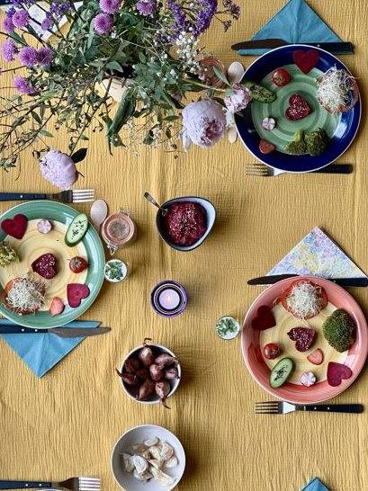 Table dressée pour le repas de reprise, assiettes colorées et fleurs